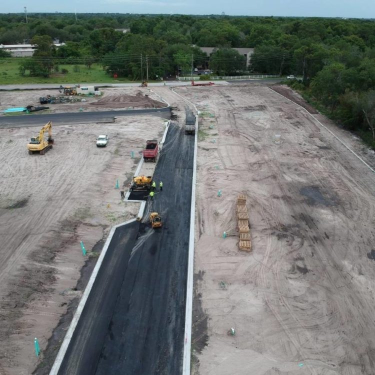 Asphalt paving a wide parking lot.