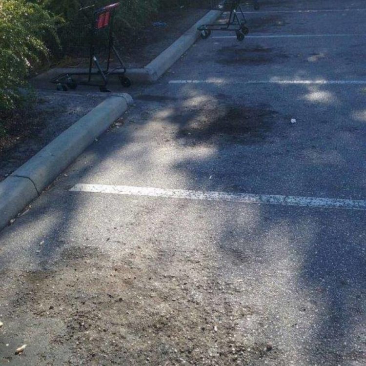 Close up image of a parking lot that needs repair and re-striping.