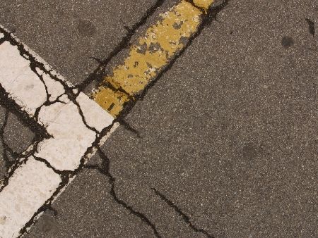 Close image of road cracks make use of asphalt paving to restore the surface.