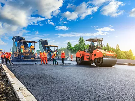 Skilled people improving a parking lot's appearance.